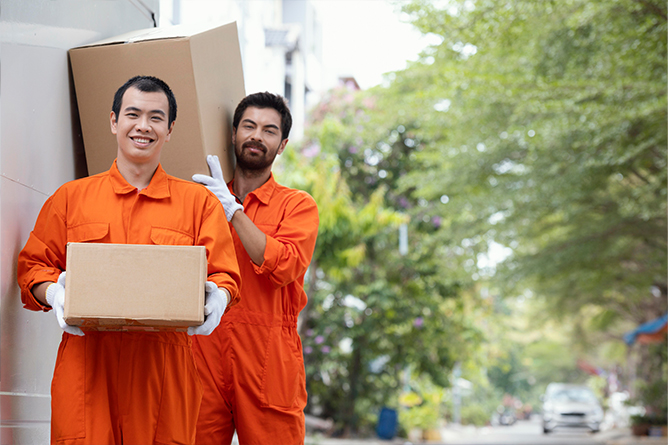 Professional delivery man with boxes providing moving services